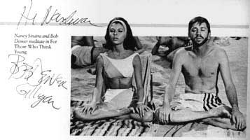 Nancy Sinatra, sitting cross-legged on a beach.